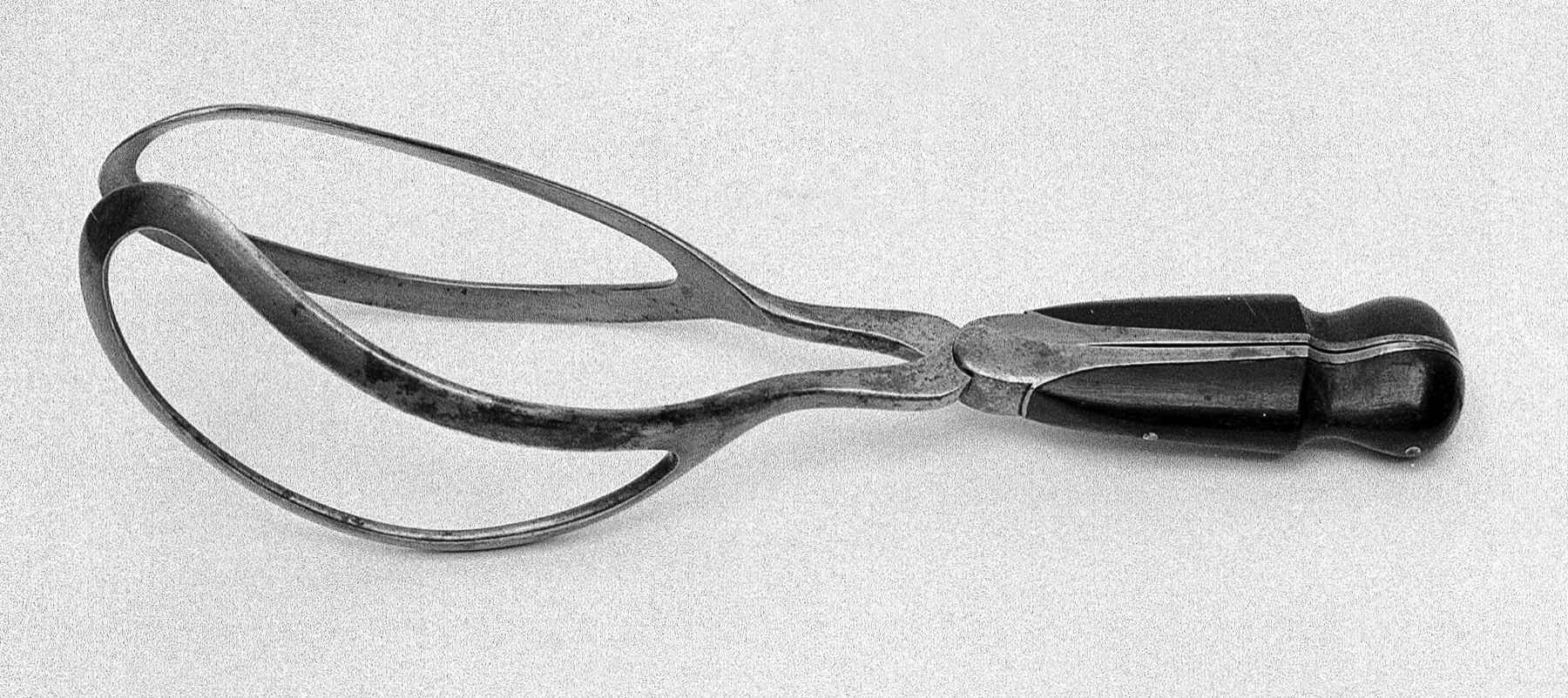 Forceps obstetrico de Davis, com laminas fenestradas e articulacao central.