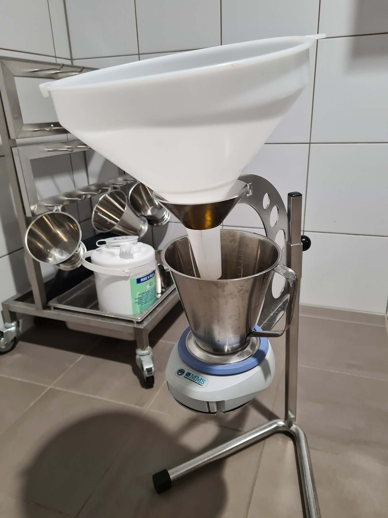 Equipamento de uroflowmetria: funil coletor sobre recipiente apoiado numa balança eletrônica (fluxômetro) do estudo urodinâmico.